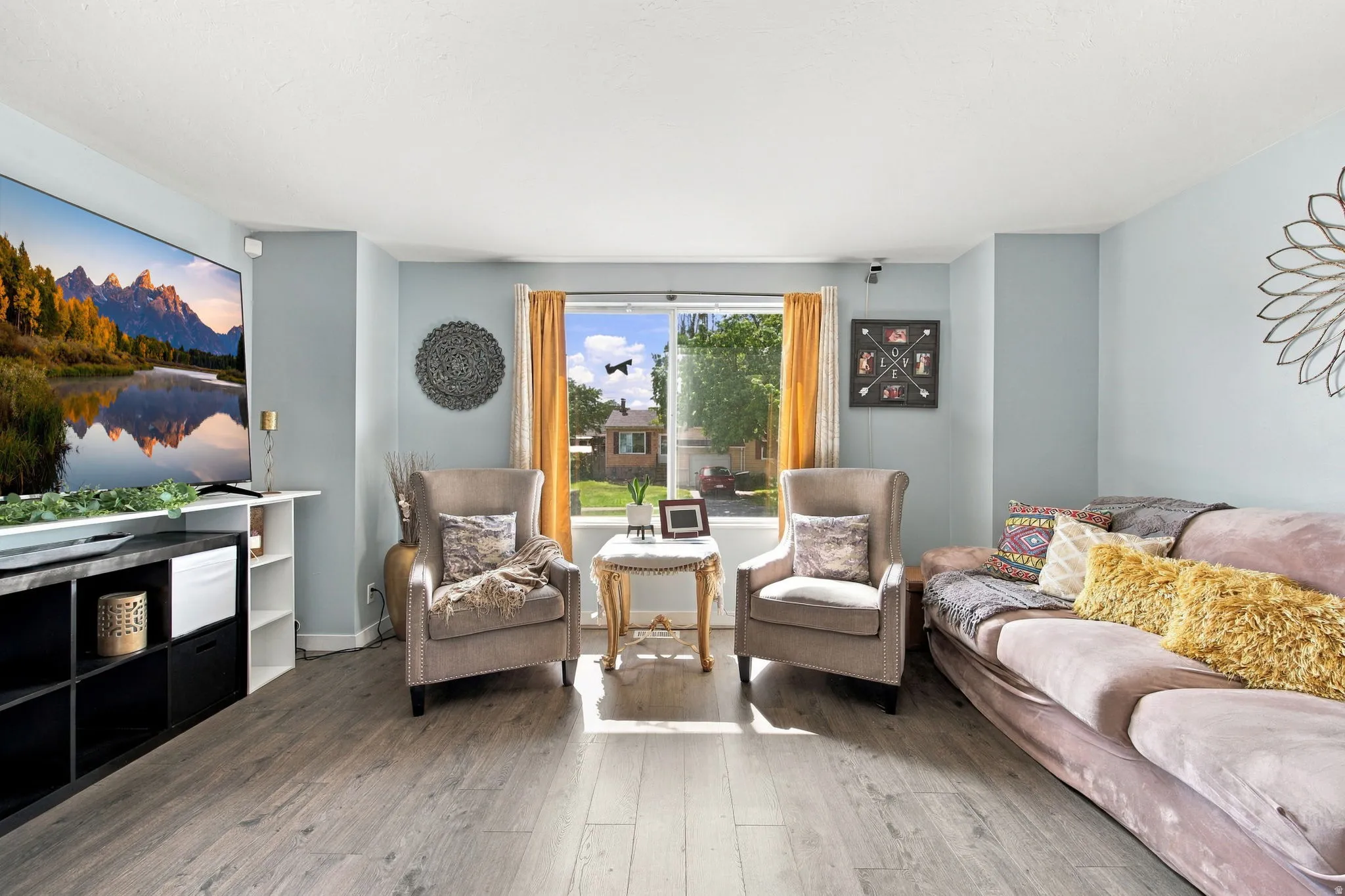 Wood-finish flooring with light-colored walls and a large window