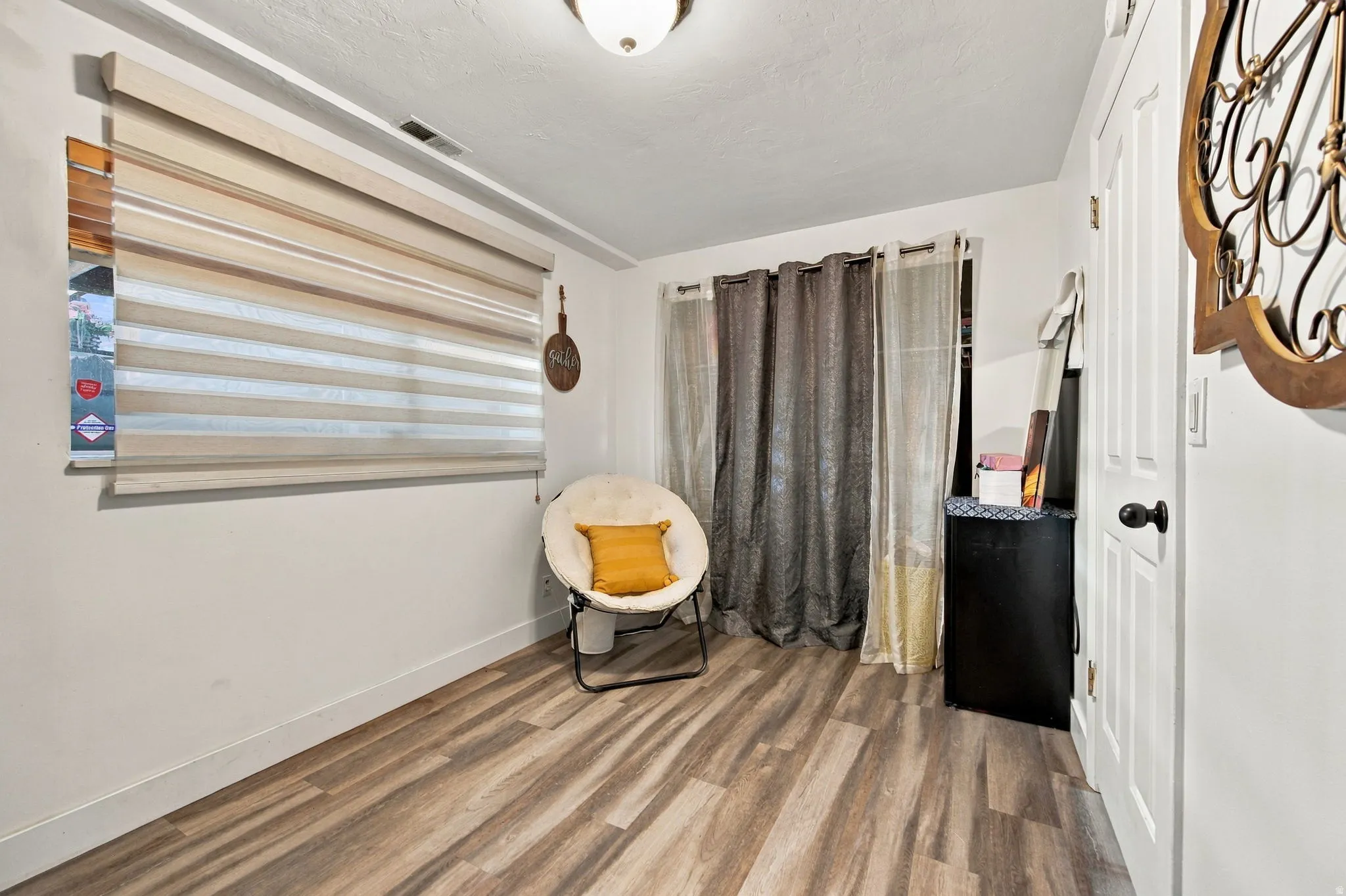 Wood-finish flooring, white walls, and a ceiling-mounted light fixture
