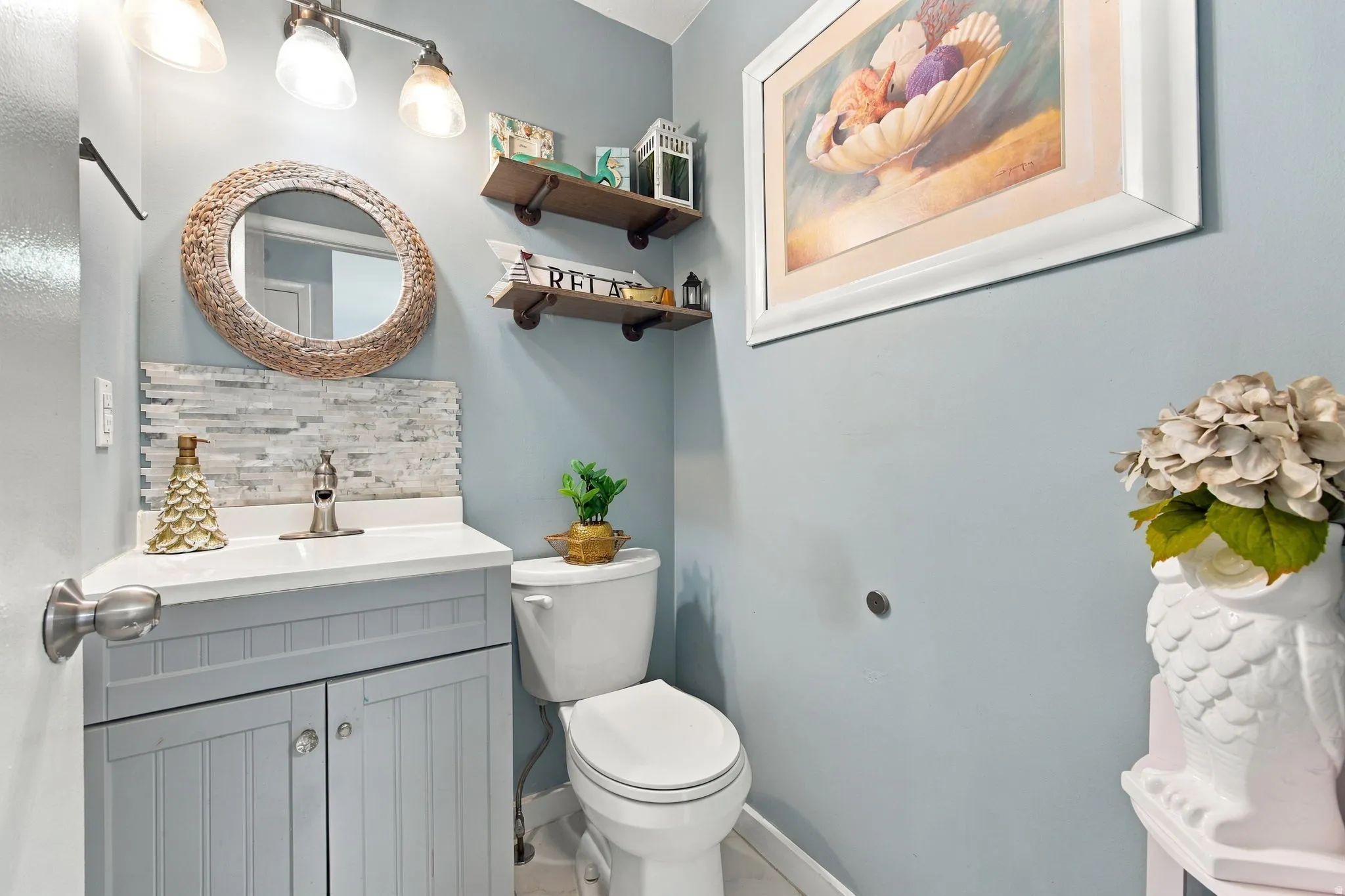 Vanity with a white countertop and integrated sink, beadboard cabinetry, and a mosaic tile backsplash