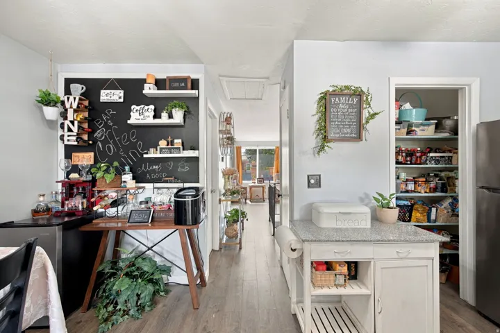 Built-in shelving, wood-finish flooring, and a kitchen island with a granite-style countertop