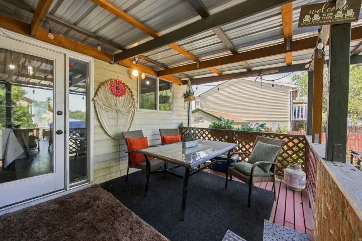 Covered outdoor patio featuring a corrugated metal roof, wood-finish decking, and lattice railing
