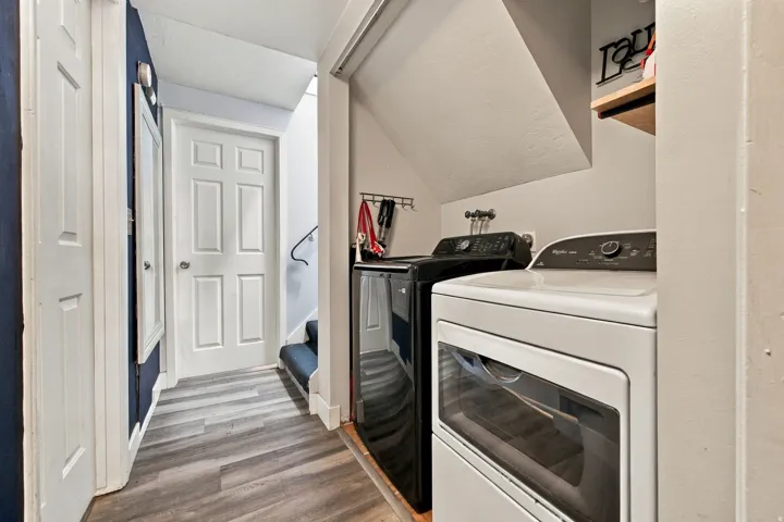 Dedicated laundry area with wood-finish flooring and integrated shelving