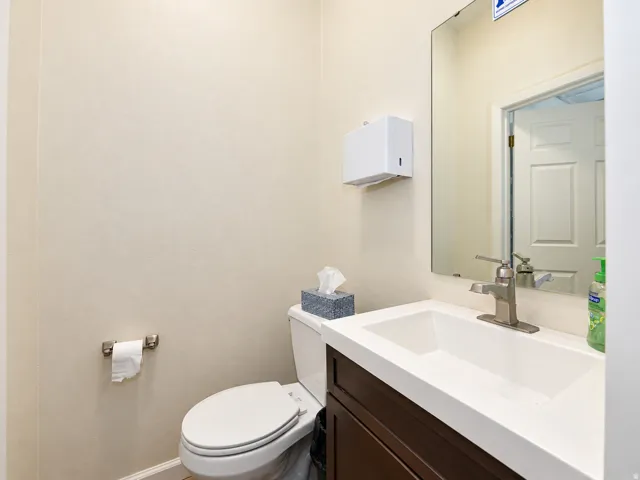 Integrated vanity with a white rectangular basin, brushed nickel faucet, and espresso-finish cabinetry