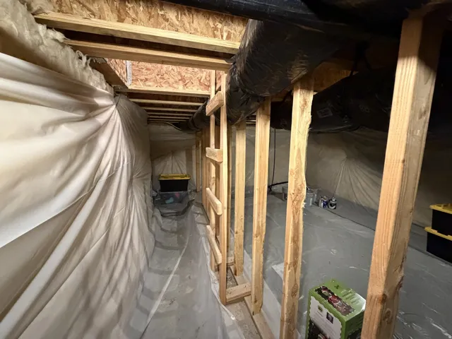 Crawl space with wood framing, exposed insulation, and durable vapor barrier