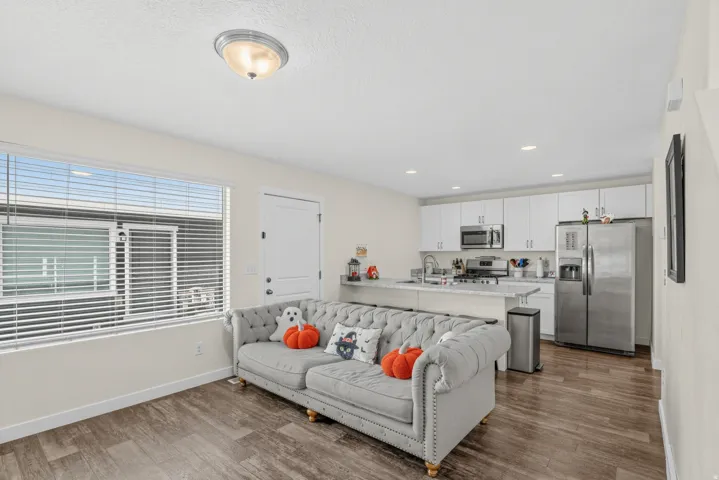 Open-concept living space with wood-finish flooring, recessed lighting, and a large window