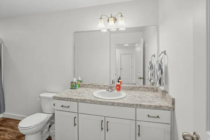 White vanity with brushed nickel hardware, integrated sink, and a light-toned countertop