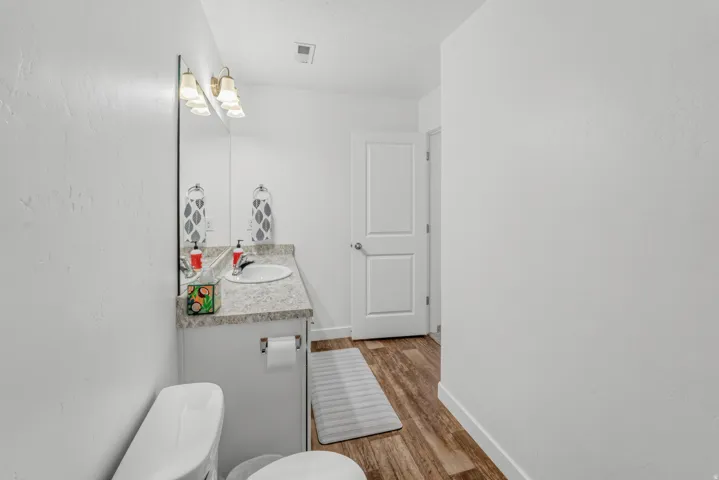 Vanity with an integrated sink, light-toned countertop, and mounted light fixture
