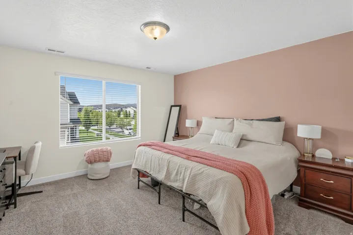 Spacious bedroom featuring carpeted flooring, a large window with blinds, and a flush mount ceiling light fixture