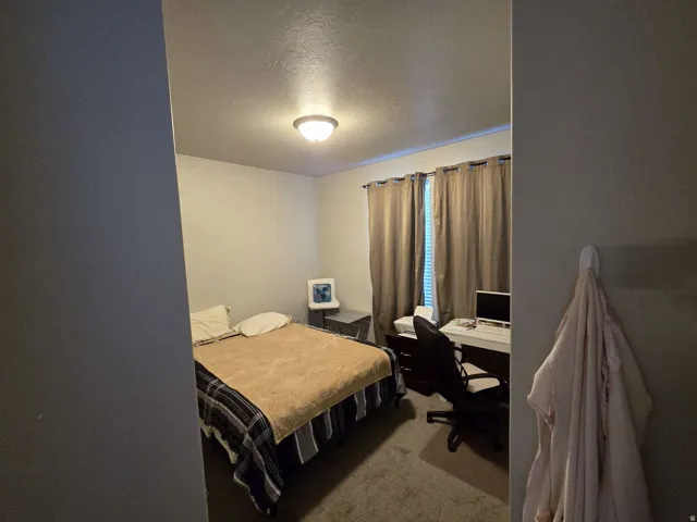 Neutral wall color, wall-to-wall carpeting, recessed ceiling light fixture, window with blinds, and curtain rod installation