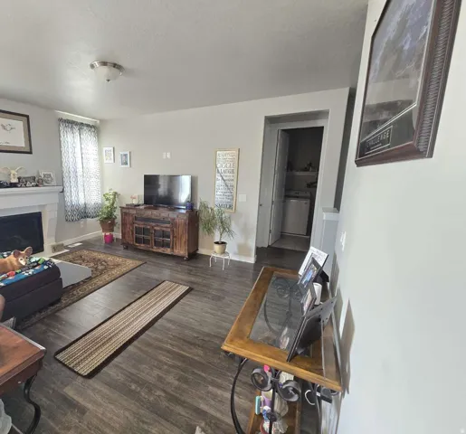 Wood-finish flooring throughout, fireplace with a mantle, recessed laundry area