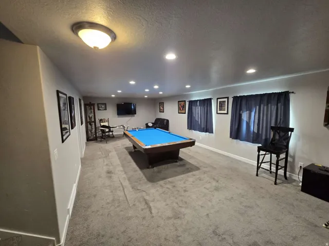 Spacious recreation area featuring recessed lighting, multiple windows, and light gray carpeting