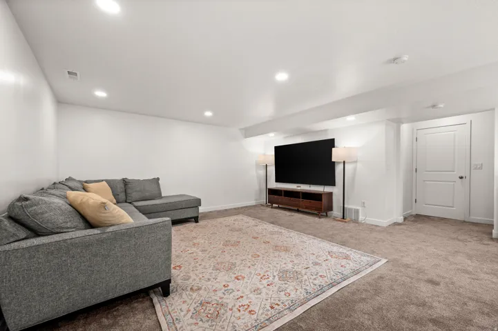 Recessed lighting illuminates this carpeted room with a permanent doorway