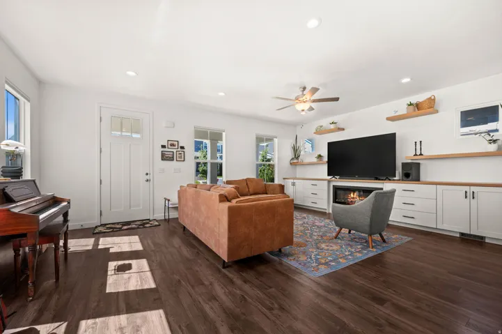 Dark wood-finish flooring throughout, white walls, and a white ceiling with recessed lighting