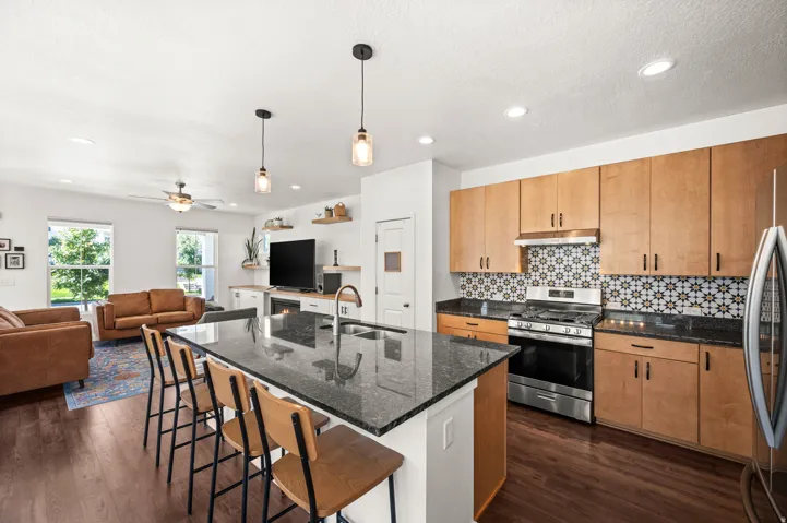Open-concept living space featuring wood-finish flooring, recessed lighting, and a ceiling fan