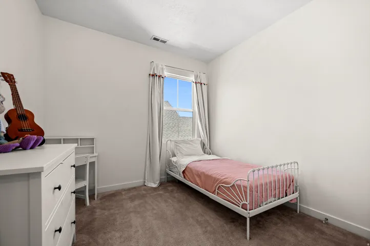Plush carpeted flooring and a window with natural light