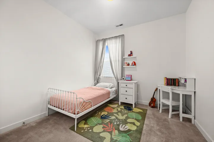 Neutral wall paint, carpet flooring, window with drapes, and floating wall shelves