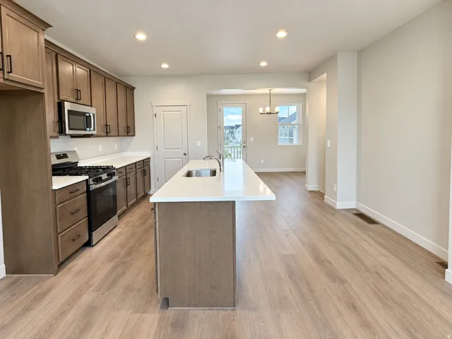 Kitchen featuring wood-finish cabinetry, stainless steel appliances, and white countertops