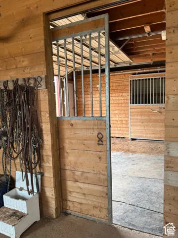 Wood-paneled interior walls, metal-barred stable door, and additional stall structures