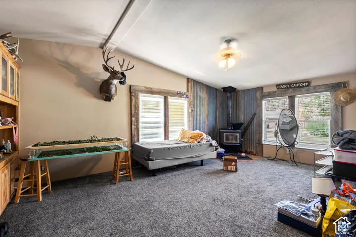 Wood-burning stove, two windows, textured wall accent, wood-frame windows, ceiling-mounted light fixture