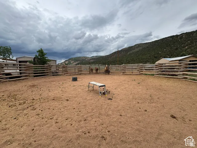 Expansive outdoor arena featuring natural wood fencing and a dirt surface