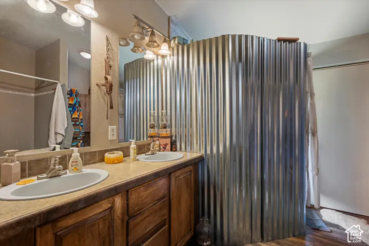Dual vanity with undermount sinks, wood-finish cabinetry, and a neutral countertop