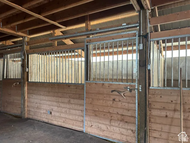 Multiple stalls featuring wood paneling, metal bar fronts, and sliding metal doors