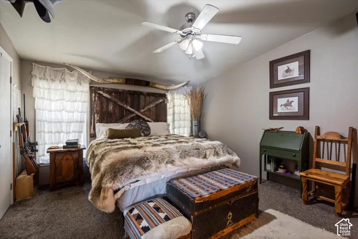 Ceiling fan with integrated lighting, textured wall finishes, and carpeted flooring