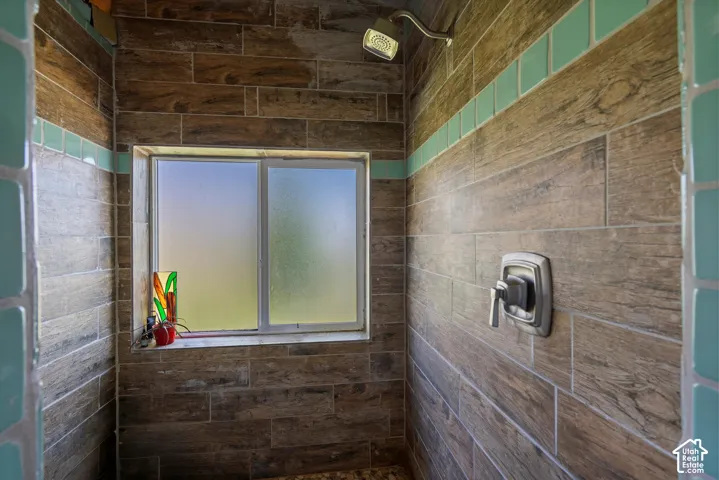Shower enclosure with wood-finish tile walls and a tiled accent band
