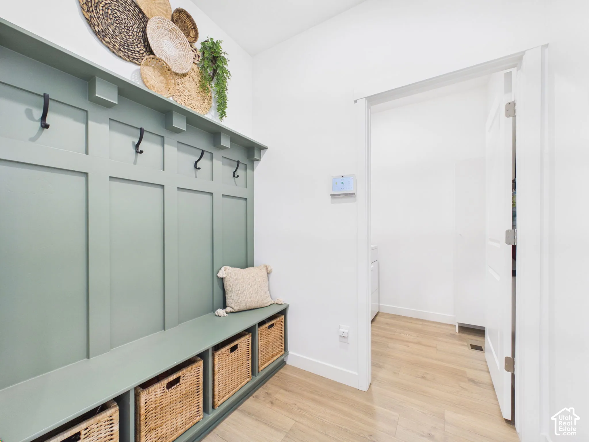 Built-in storage bench with woven basket cubbies and wall-mounted coat hooks