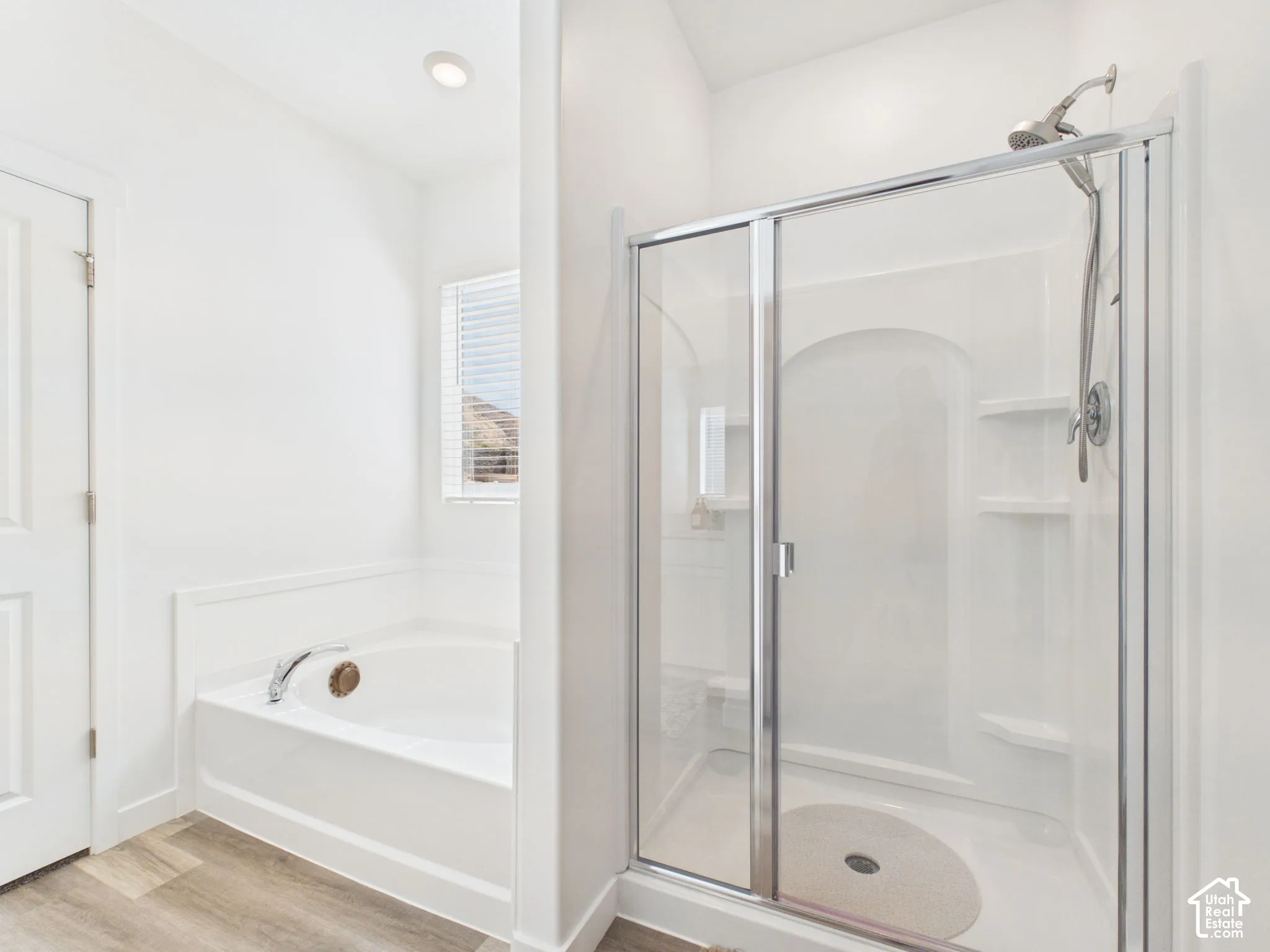 Walk-in shower with a glass enclosure, built-in shelving, and a chrome shower head