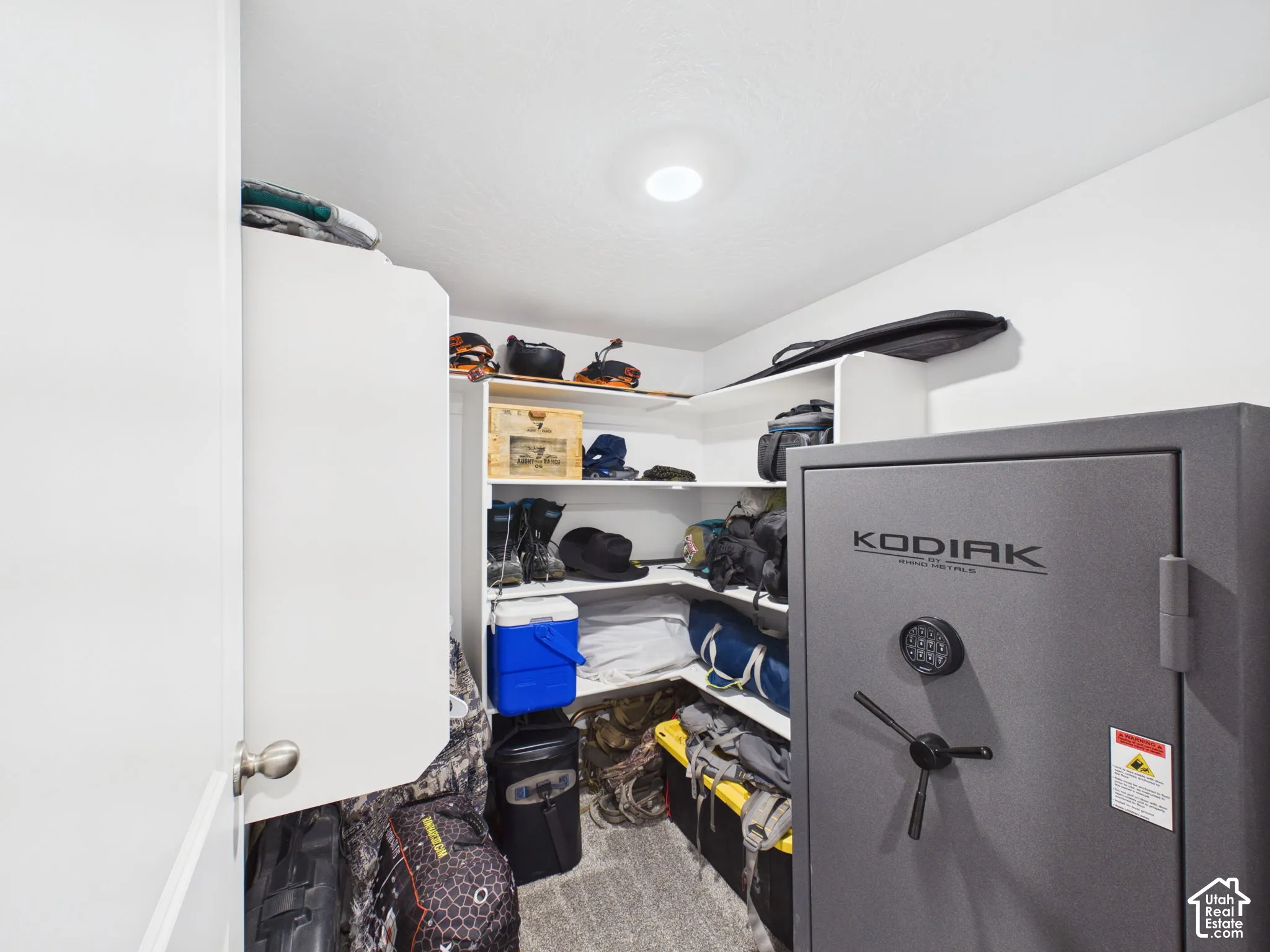 Walk-in closet with built-in shelving, recessed lighting, and a neutral color palette