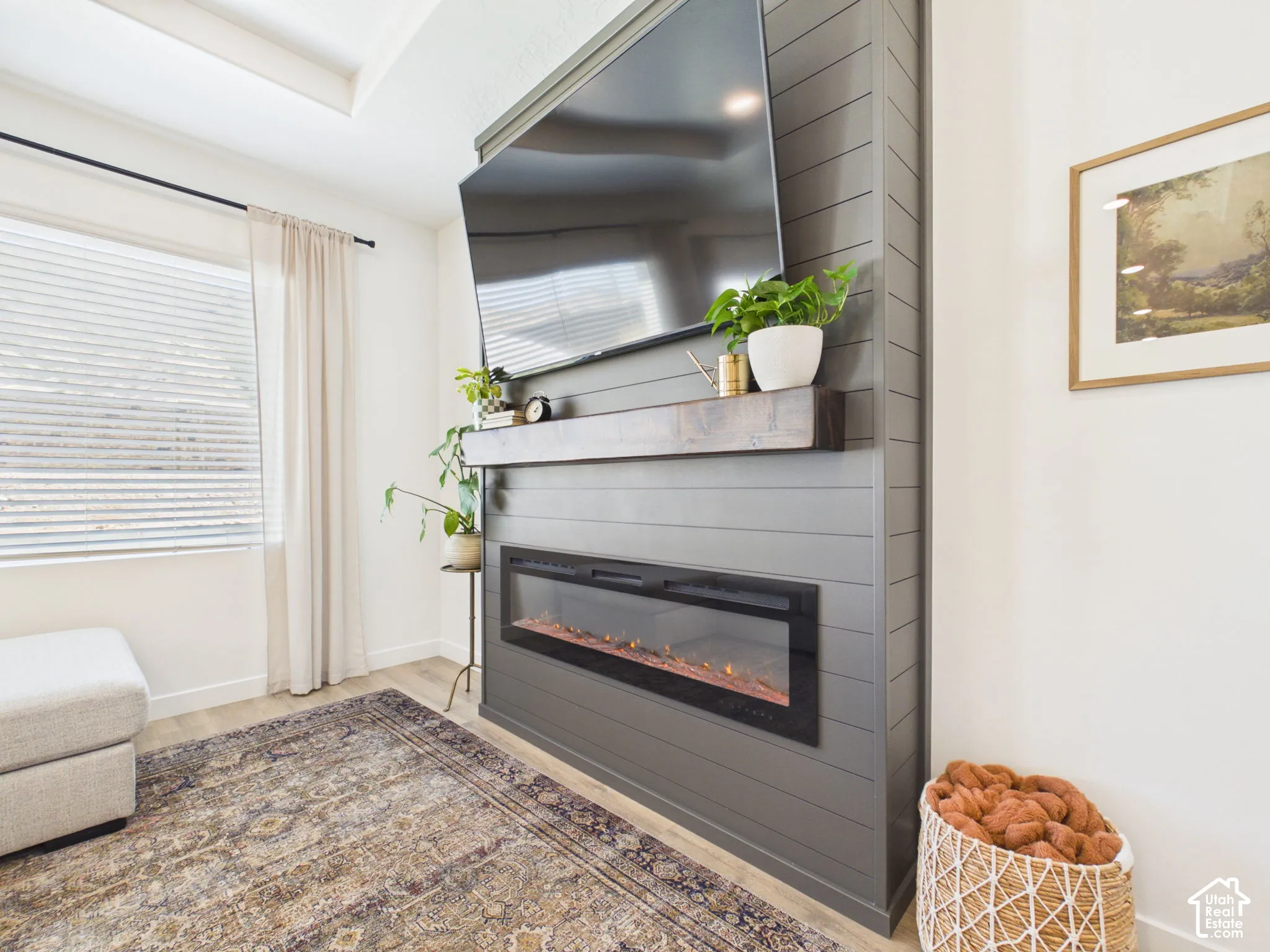 Shiplap accent wall with built-in electric fireplace, wood-finish flooring, and recessed ceiling