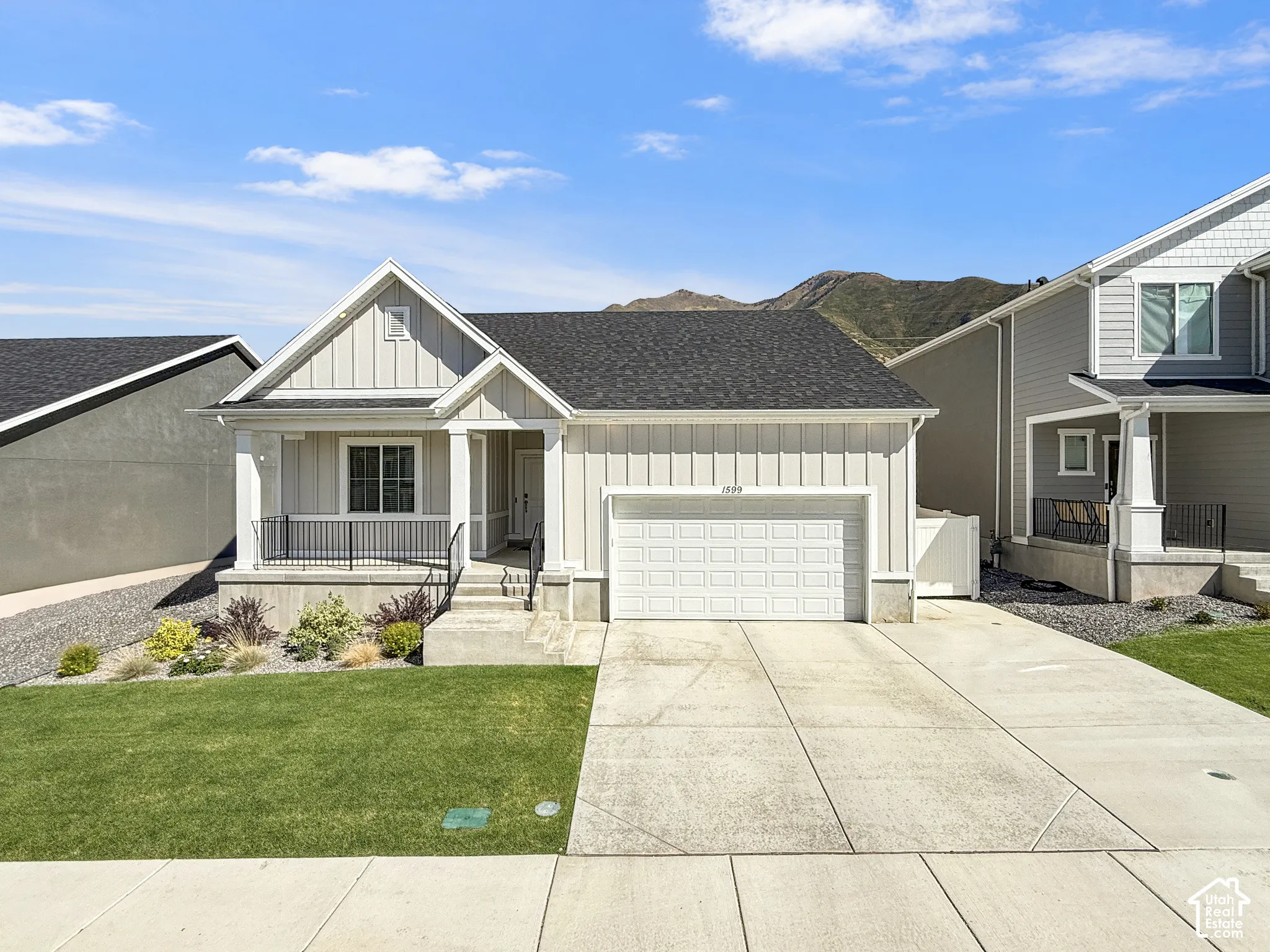 Single-story residence featuring a covered front porch, attached garage, and a concrete driveway
