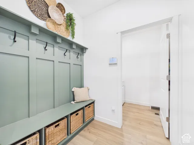 Built-in storage bench with woven basket cubbies and wall-mounted coat hooks