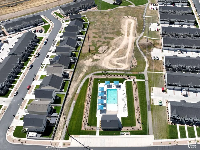 Community featuring multi-family residences, a communal swimming pool, a clubhouse structure, and landscaped green spaces