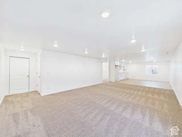Recessed lighting, wall-to-wall carpeting, wood-finish flooring, white cabinetry, and white paneled doors