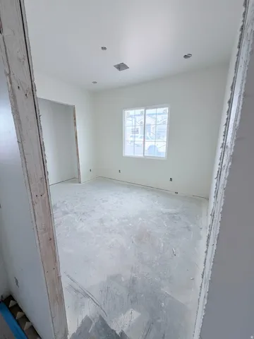 Recessed lighting, white walls, and a window with white framing