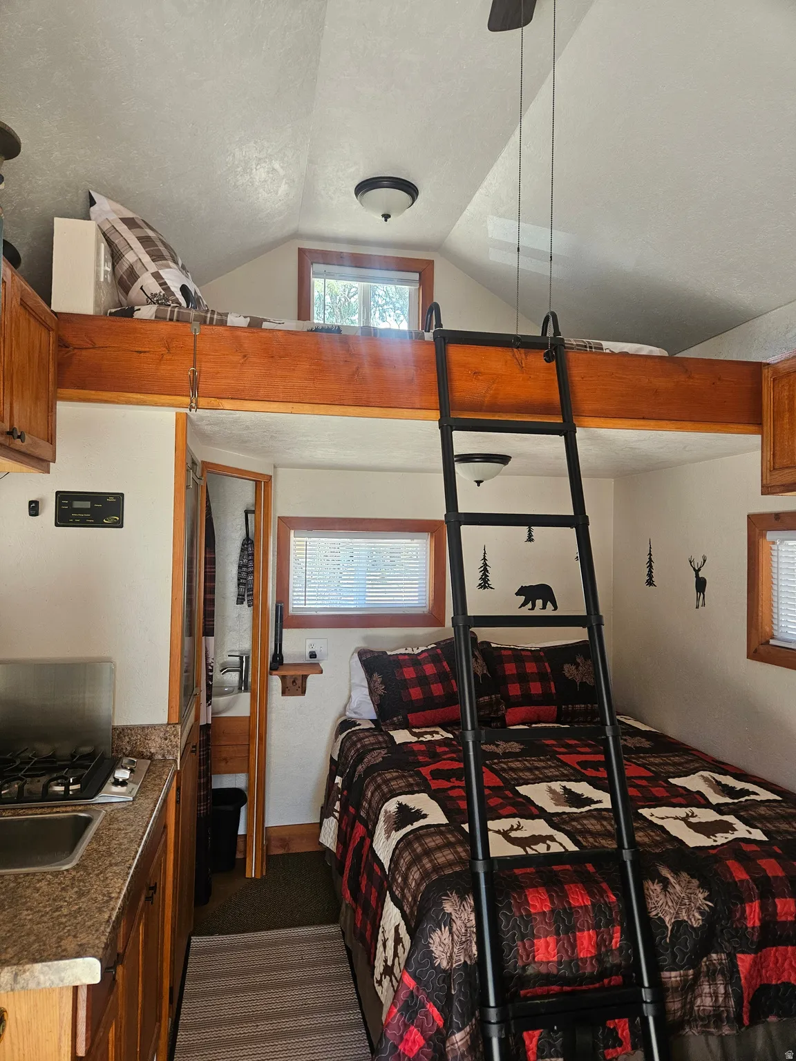 Compact living space featuring wood-finish cabinetry, a built-in gas cooktop, and a stainless steel sink