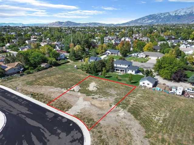 Expansive lot with a clear building envelope, established neighborhood surroundings, and distant mountain backdrops