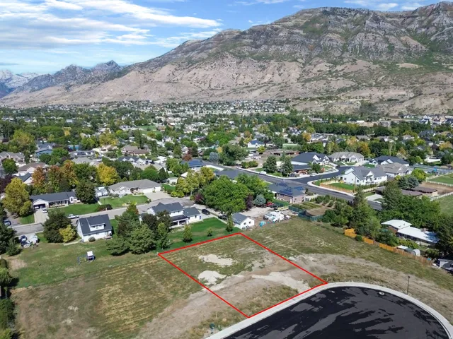 Open land parcel with mountain backdrop, surrounded by established residential properties