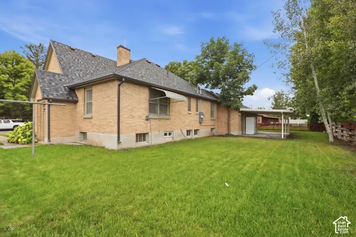 Brick exterior, asphalt shingle roof, chimney, covered patio, mature trees