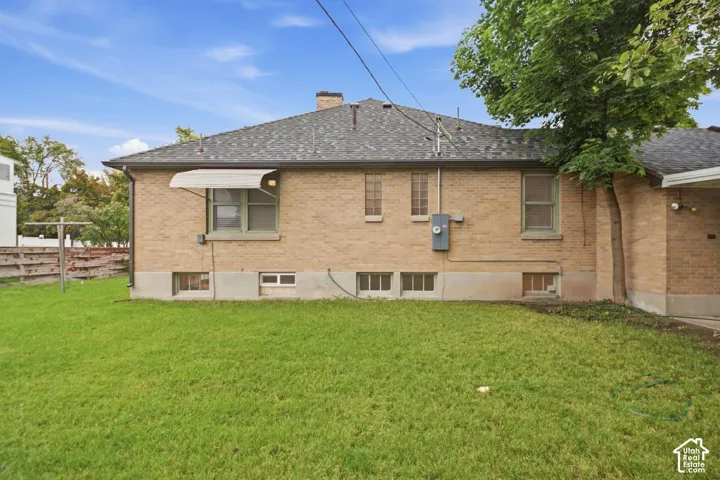 Brick exterior with a shingle roof and foundation plantings