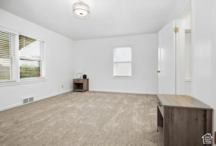 Neutral-toned carpeting spans the room, complemented by white walls and trim