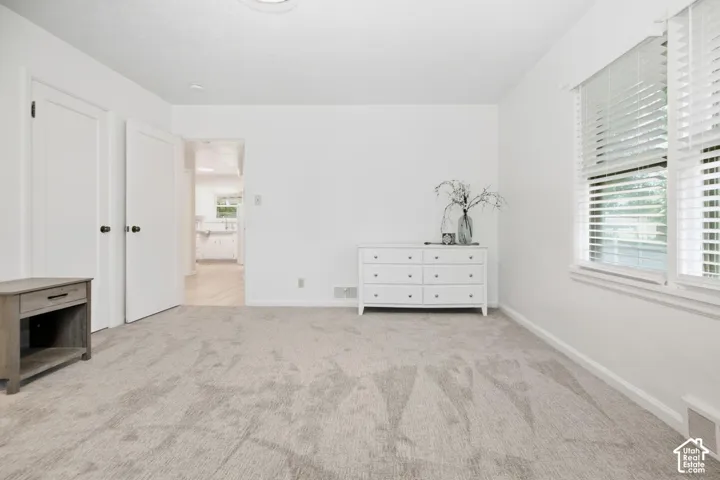 Plush carpeting, bright white walls, and a recessed ceiling light