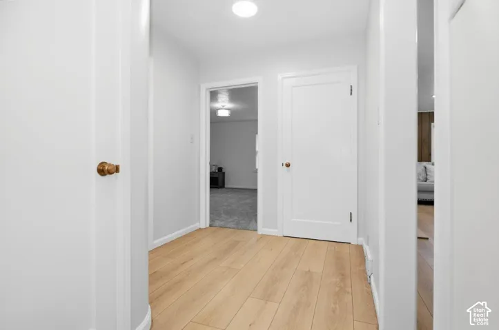 Light wood-finish flooring, white walls, recessed lighting, and white interior doors