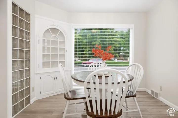 Built-in arched display cabinet, bay window, wood-finish flooring, and glass block architectural feature