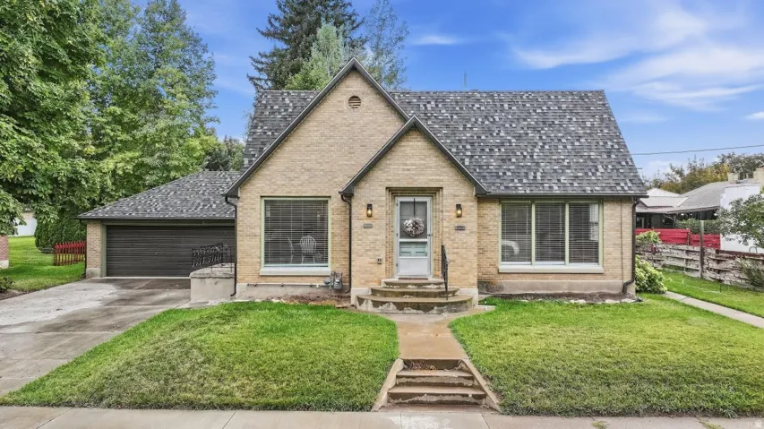 Brick exterior with a gabled roofline, attached garage, and a concrete driveway
