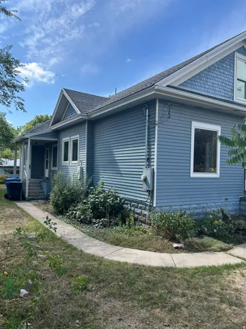 Light blue siding exterior with white trim windows and a dark shingle roof