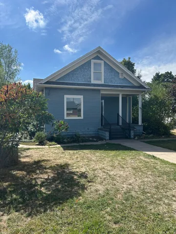 Exterior featuring horizontal siding, decorative shingle siding, a covered porch, and a sidewalk entrance