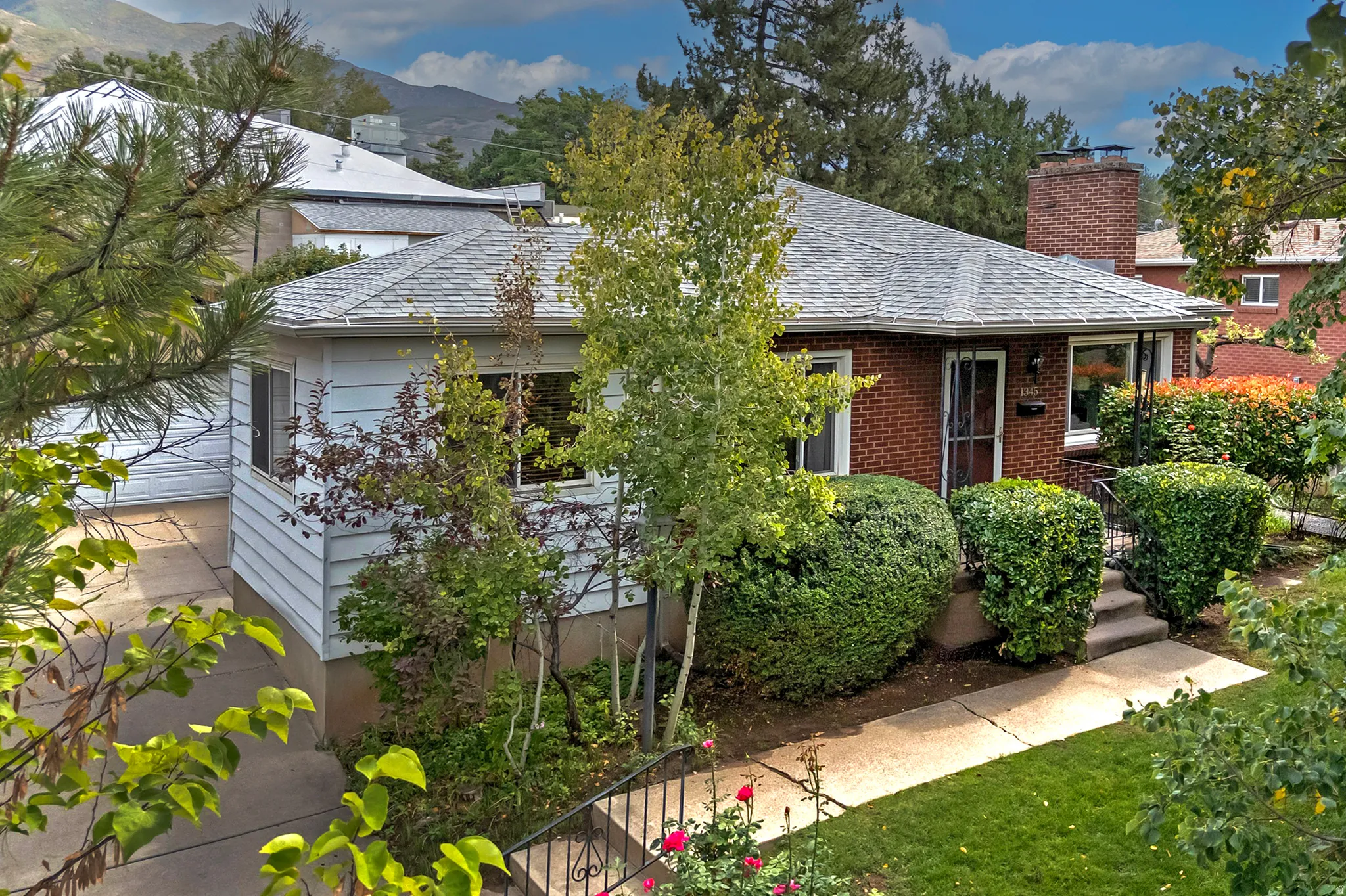 Brick exterior with a prominent chimney and a light-colored shingle roof
